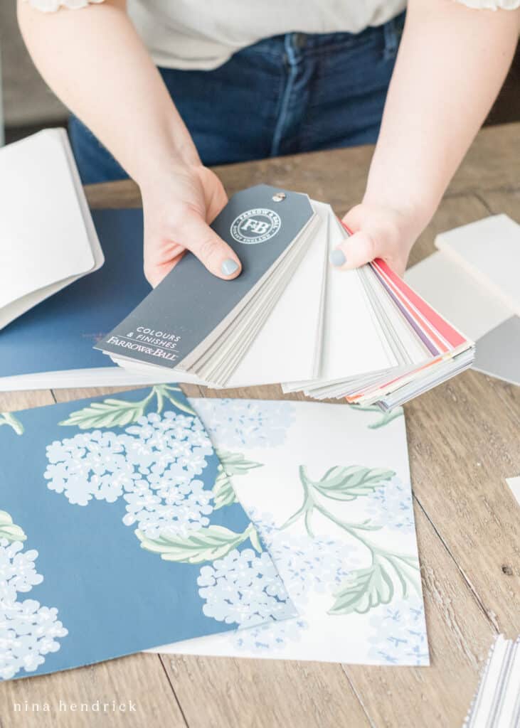A woman is holding blue and white color deck over a table