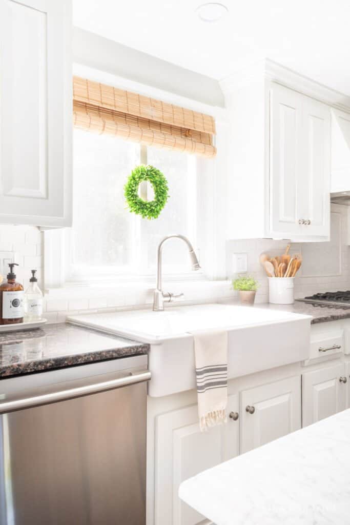 White farmhouse apron front sink in kitchen with painted cabinets 