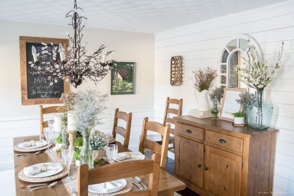 A white dining room with a wooden table and chairs.