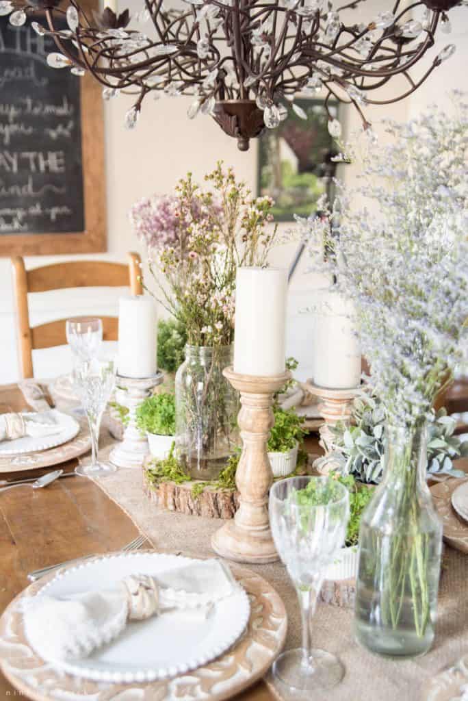 Candle sticks, place settings, and glasses on dining room table for St. Patrick's Day