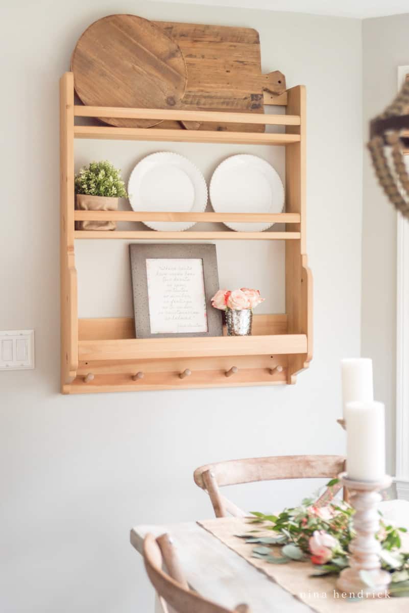 Wooden shelf with plates and roses