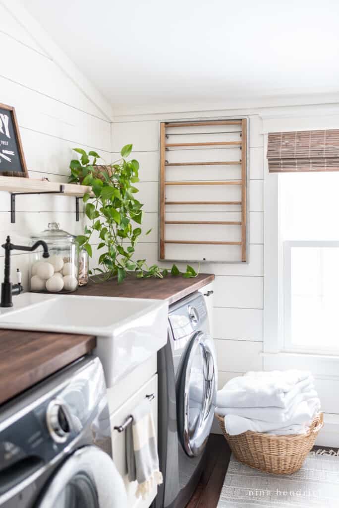 Laundry room makeover with a dark countertop and white planked walls