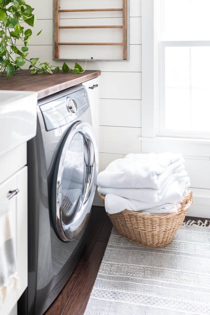 basket with freshly folded towels in front of the washer machine