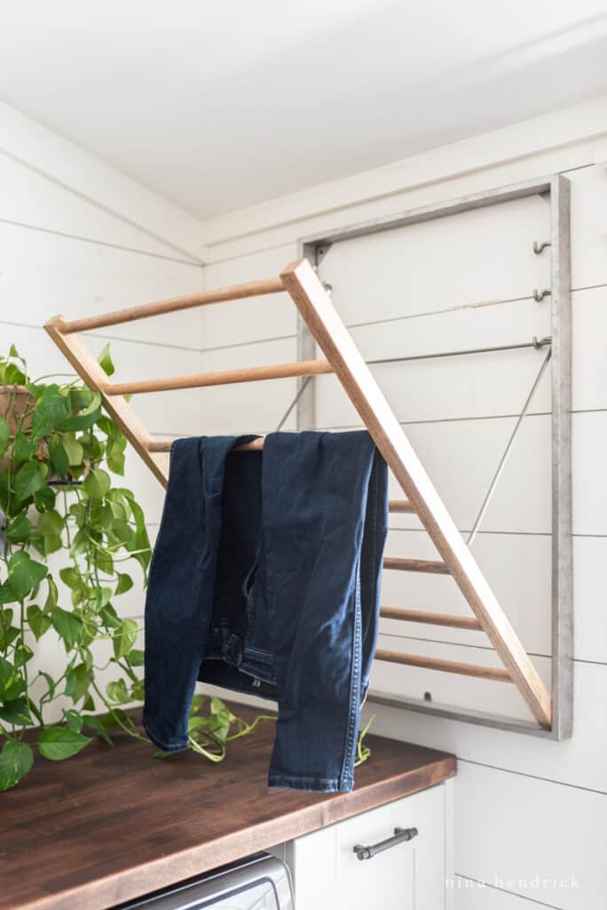 galvanized drying rack with jeans and a leafy green plant