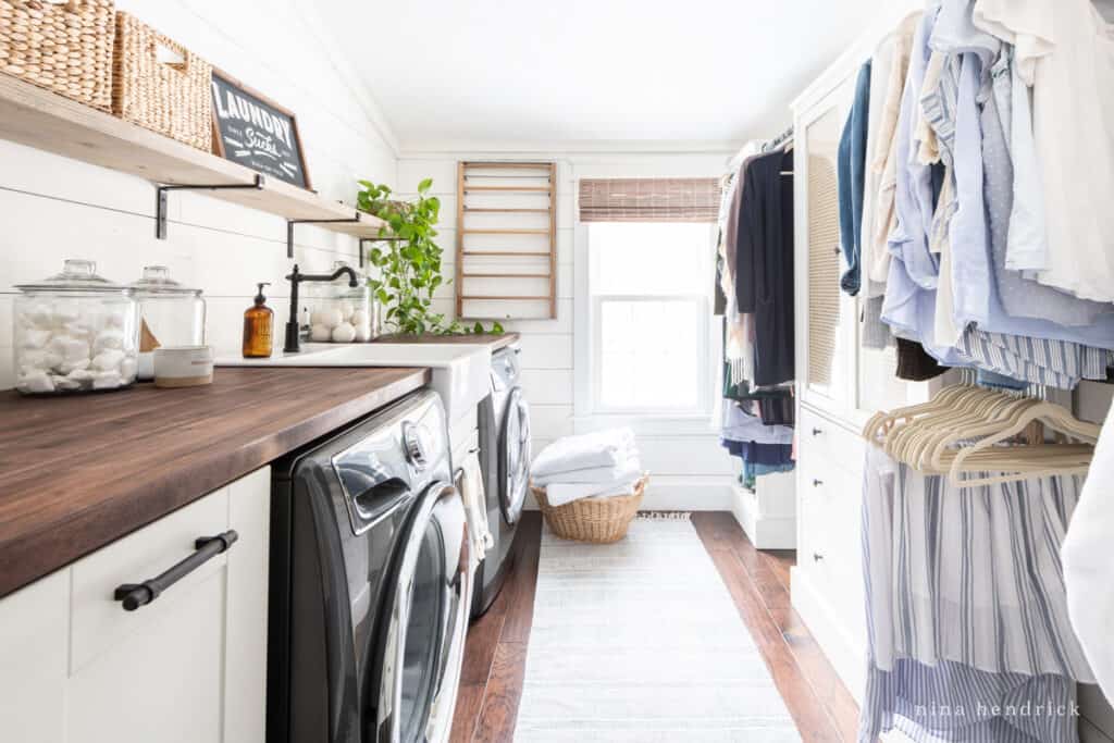 second-floor laundry room with a closet and white planked walls