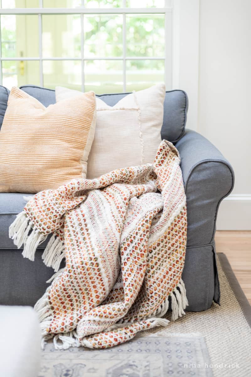 A throw blanket on a couch in a living room.