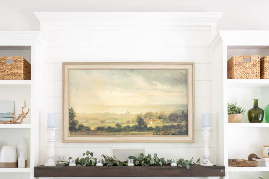 Fireplace mantel decor with a Frame TV with landscape artwork above 