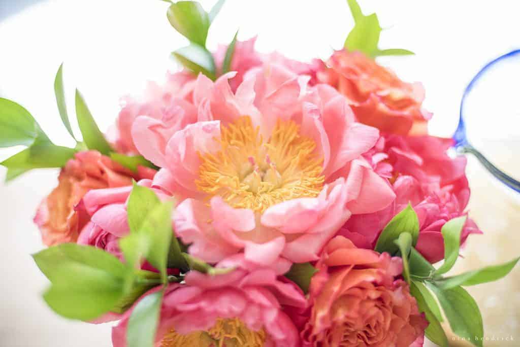 Peonies and orange roses in a floral arrangment