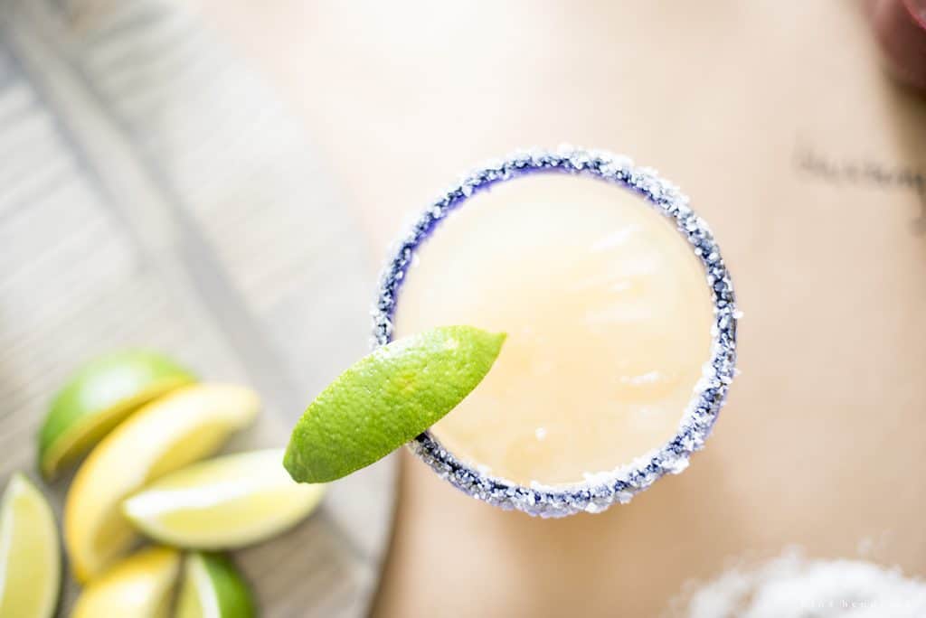 Overhead shot of a margarita with a lime wedge and a salt rim