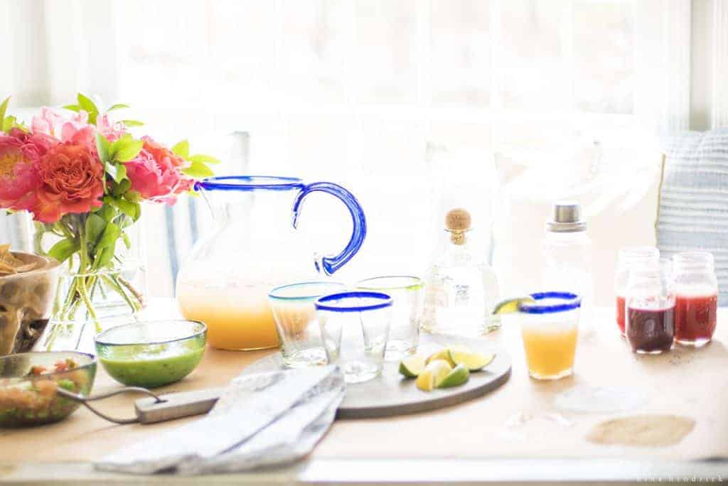 Cinco de Mayo party ideas like colorful glassware and a bright flower arrangement