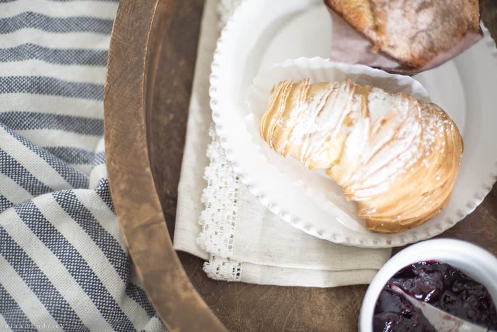 Croissant with powdered sugar on a breakfast tray