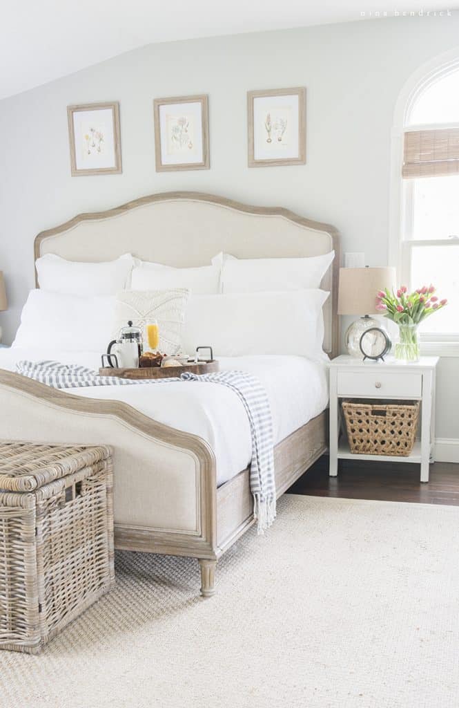 Light-filled bedroom with white linens and breakfast in bed tray for Mother's Day.