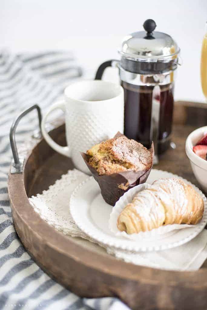 Wooden breakfast in bed tray with patries and a french press