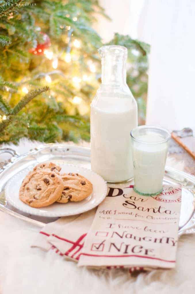 Cookies and milk for Santa are a cozy Christmas decorating idea in front of the tree with glowing twinkle lights.