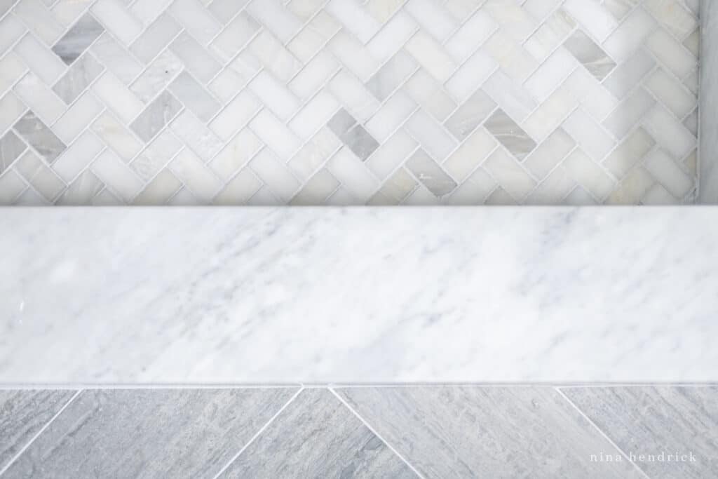 Mixing tile in a bathroom: concrete-look, marble, and herringbone small tile