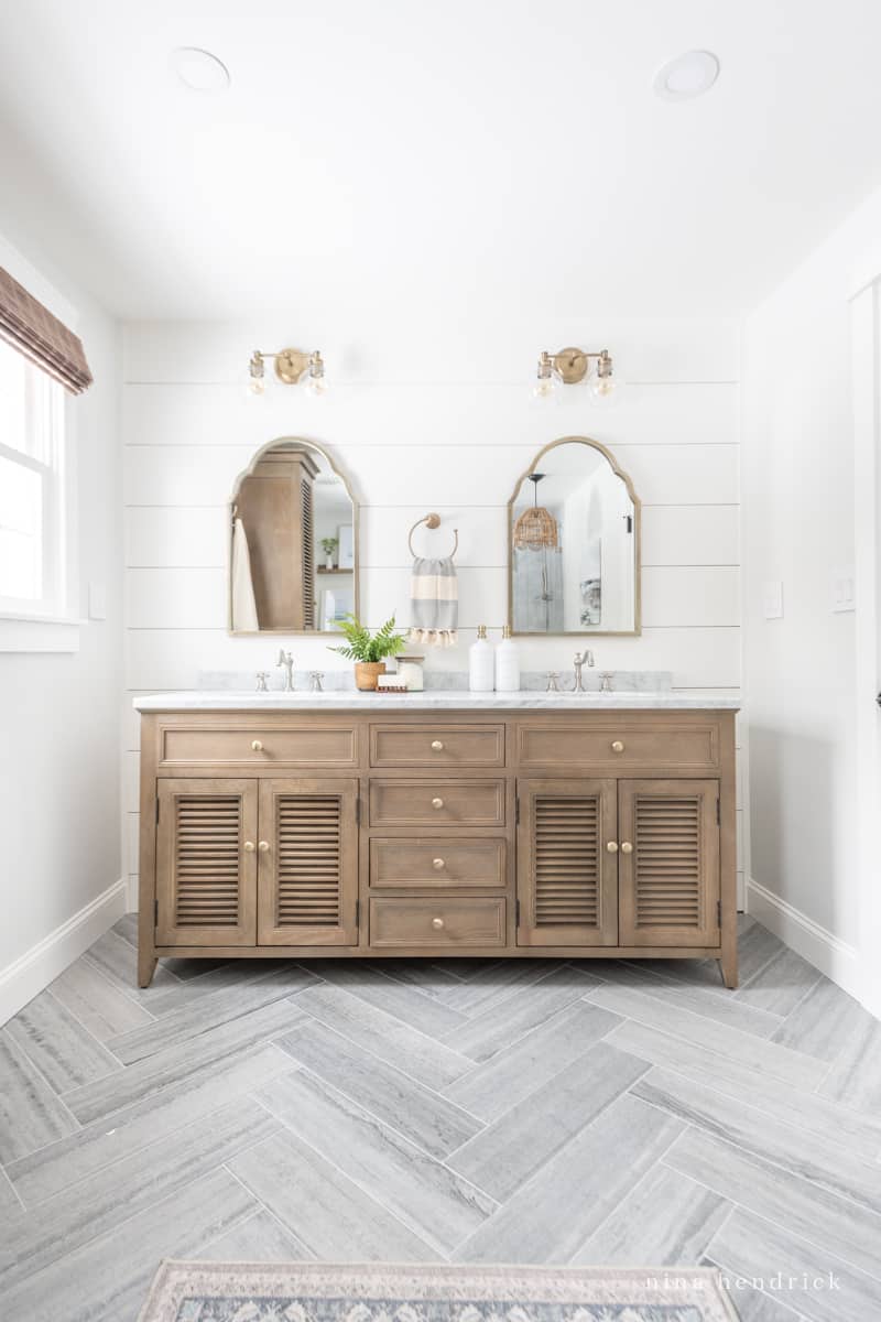wood bathroom vanity with herringbone concrete-look tile floor