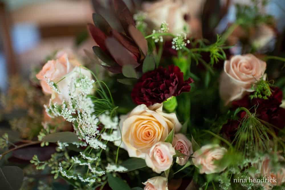 Roses, red carnations, queen anne's lace floral arrangement