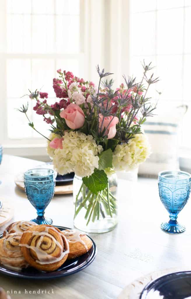 floral arrangement and a plate of breakfast pastries