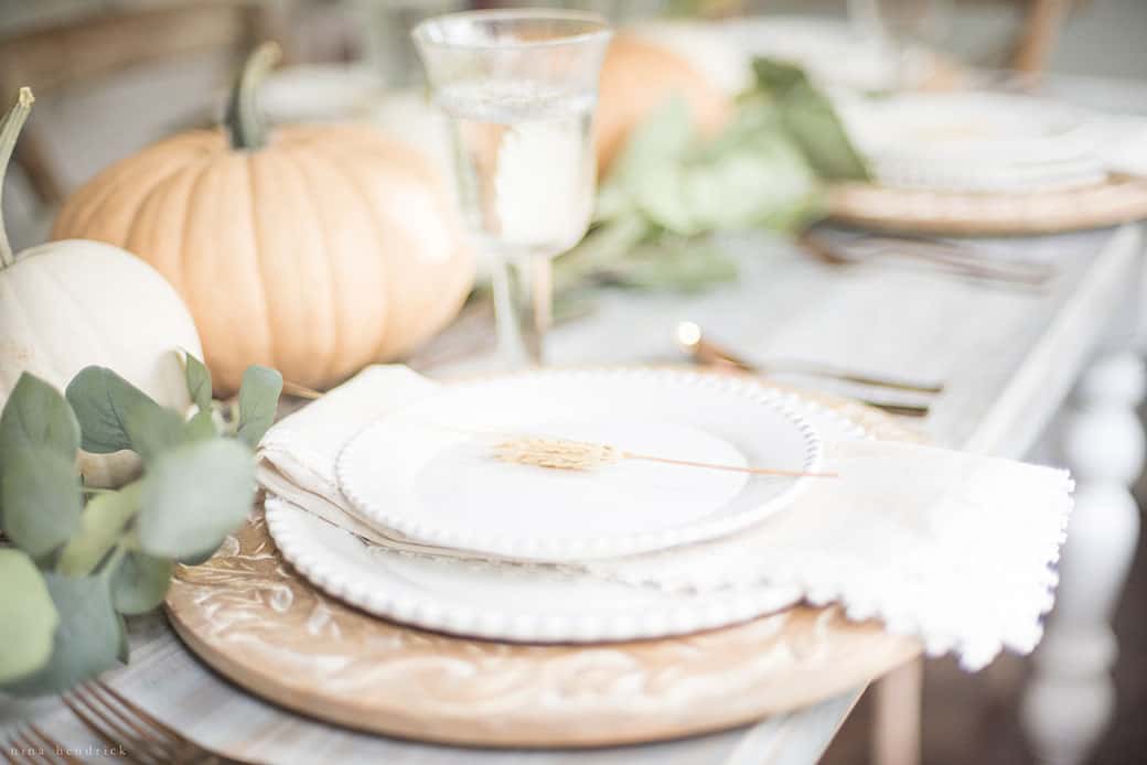 Simple fall tablescape featuring pumpkins and eucalyptus leaves.
