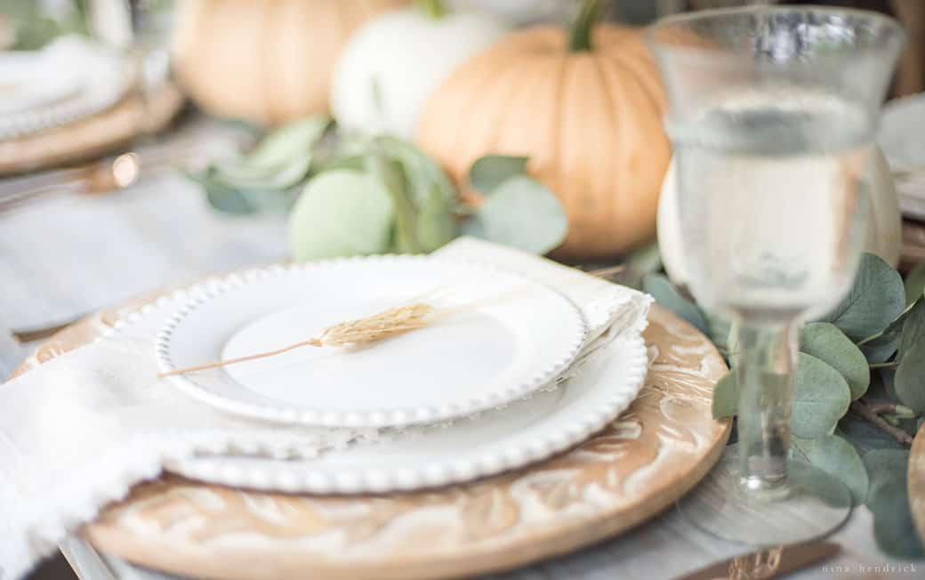 Simple fall tablescape featuring eucalyptus and pumpkins.