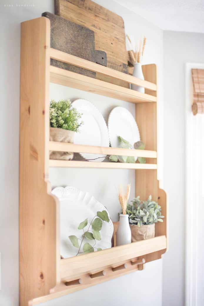 A wooden shelf adorned with white plates