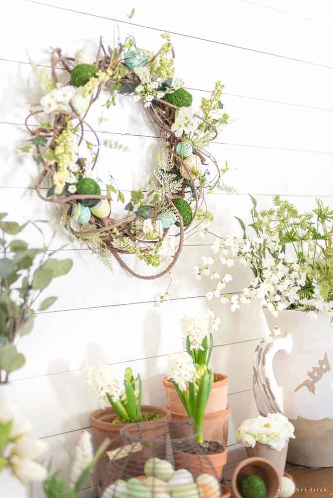 spring wreath hanging with pots and eggs