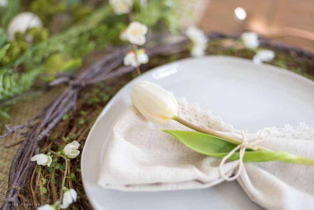 different angle of white tablesetting with tulip and napkin