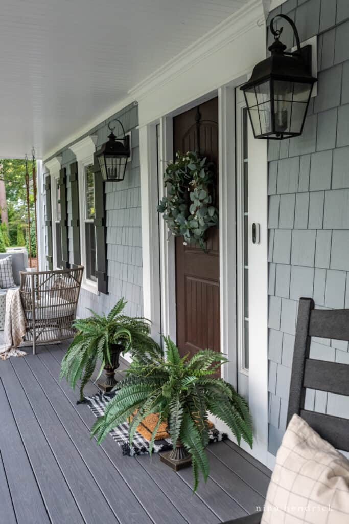 Wood look front door with faux ferns and a wreath