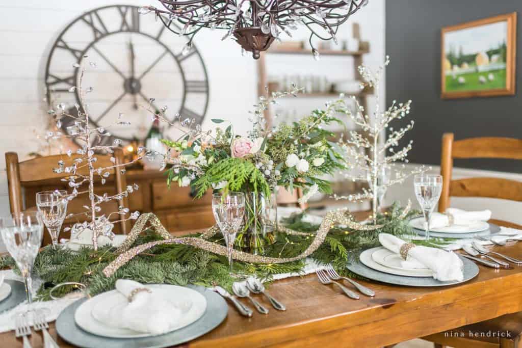 New Year's Eve Tablescape with evergreens and glittering ribbon
