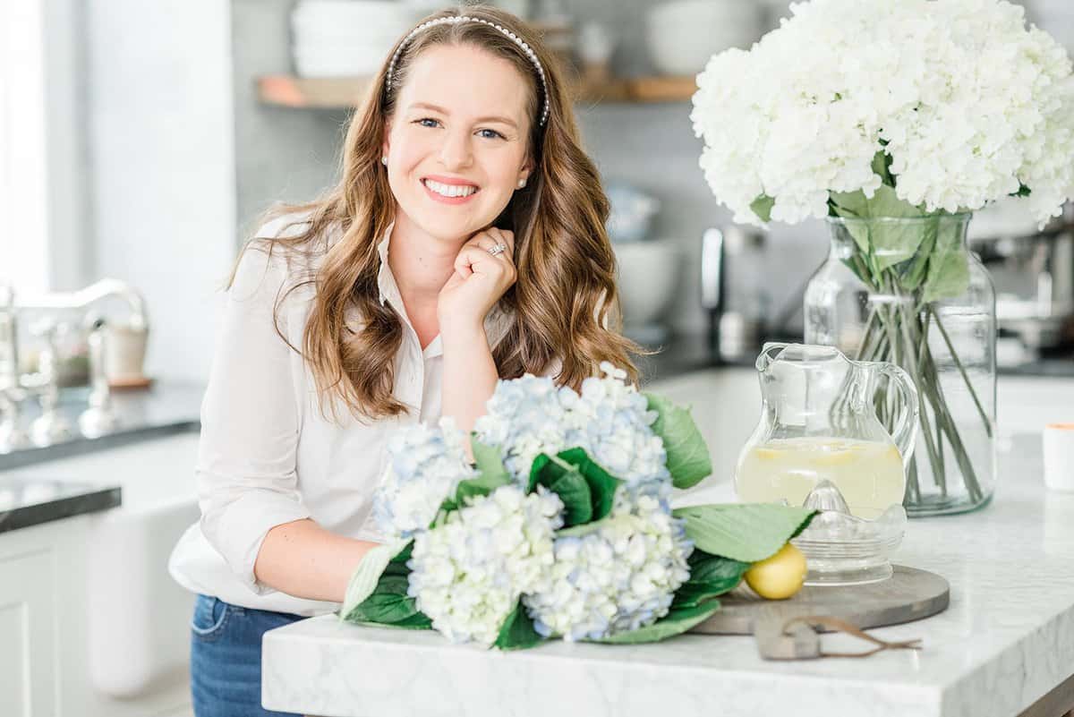 A woman named Nina Hendrick sitting at a table in a home office.