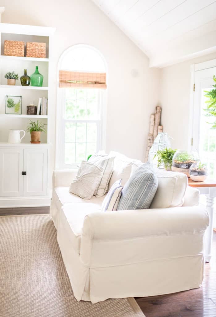 White family room with built-ins and blue throw pillows with a white couch
