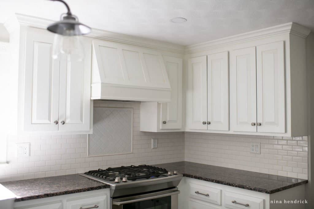 kitchen range hood and white cabinets five years after painting