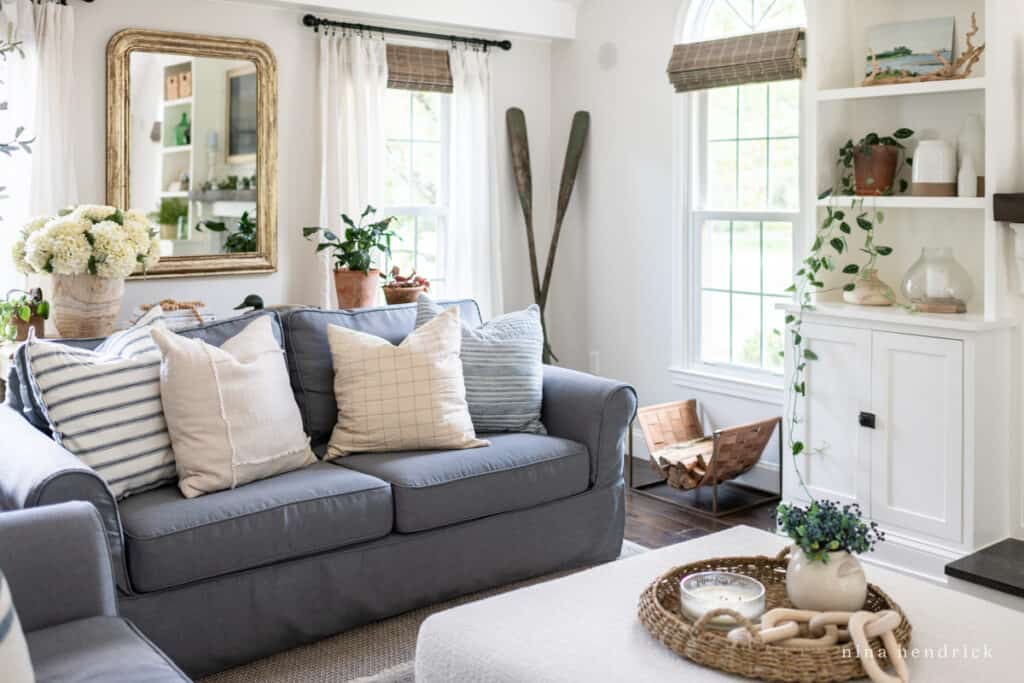 Family room with dark couches and light colored built-ins with a lot of greenery