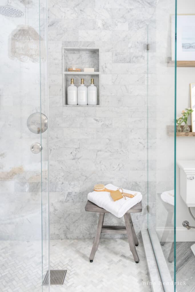 Carrara marble tiled shower with a glass surround