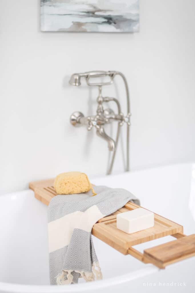 wood tub tray with sea sponge and rustic soap on a turkish towel