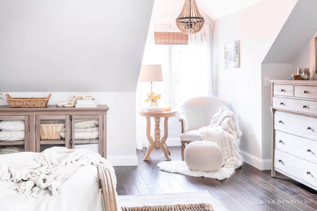 A cozy reading nook with fur throws and a wood bead chandelier