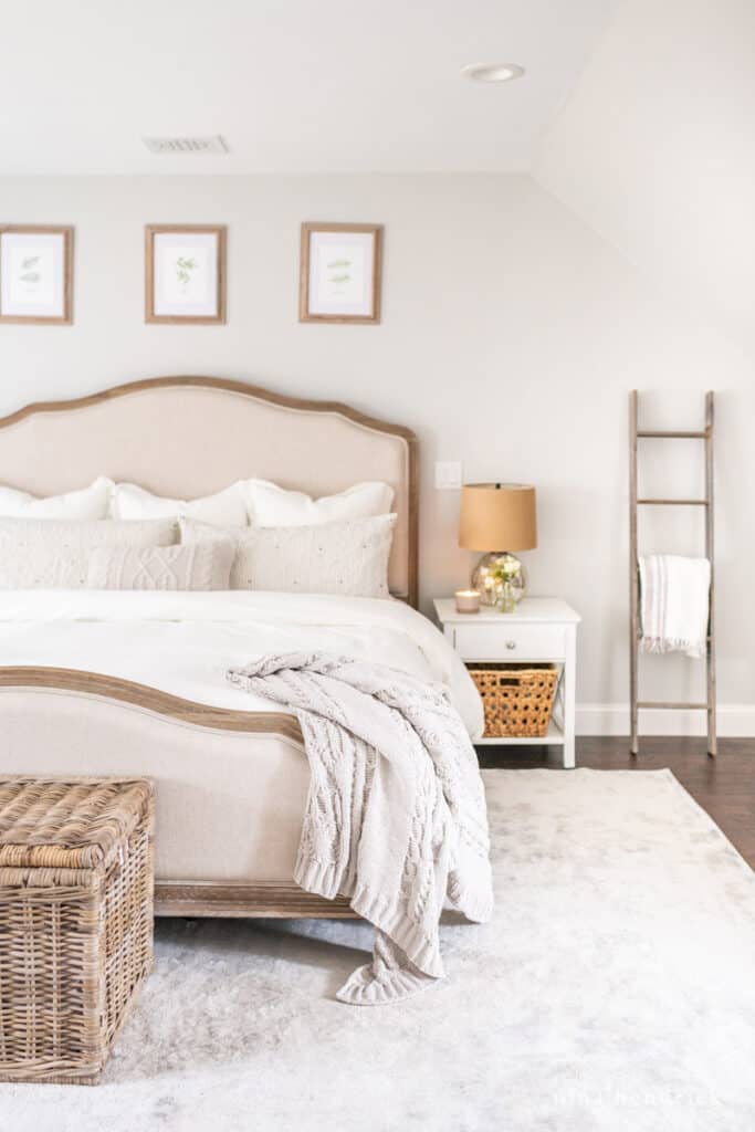 A cozy and neutral primary bedroom makeover with linens and a gorgeous vintage-style rug