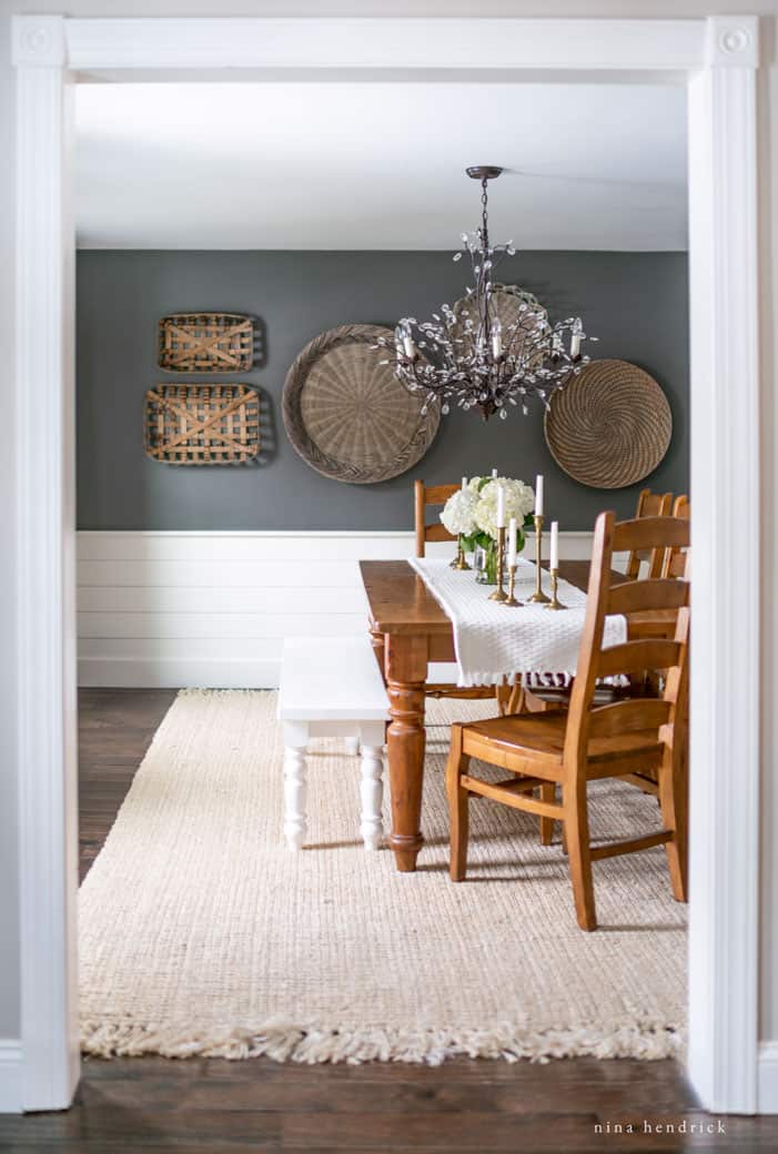Dining room with dark walls and a 8x10' size jute rug with fringe