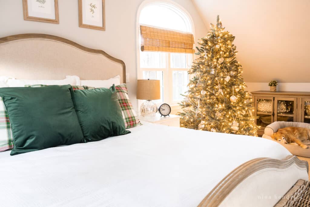 Bedroom decorated for a rustic holiday with a glowing Christmas tree. 