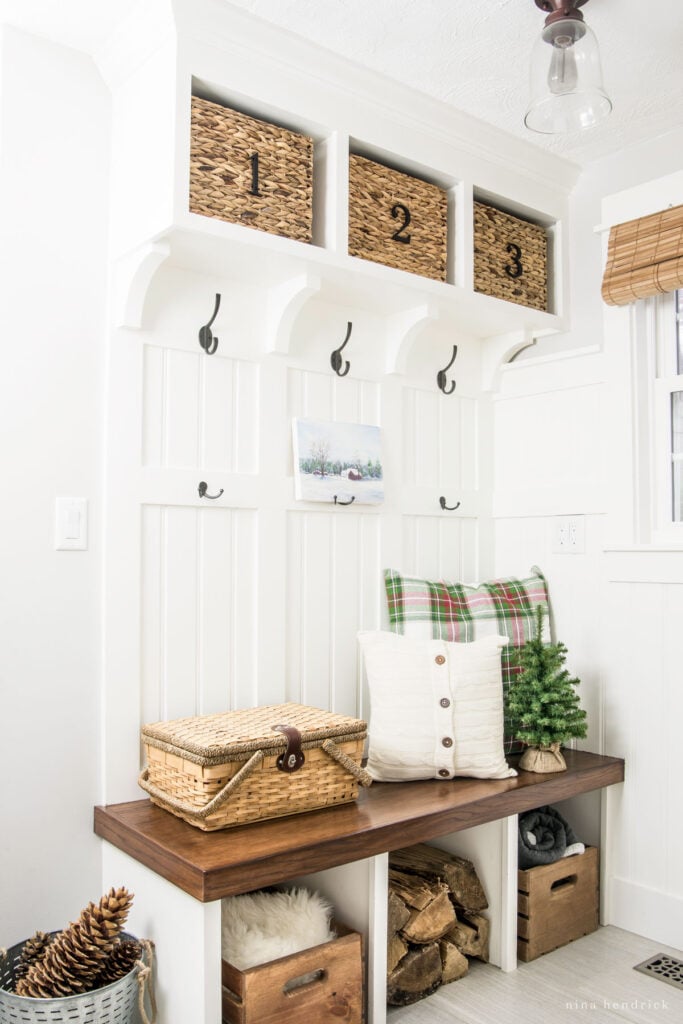 Mudroom bench with rustic logs and pinecones plus other Christmas decor. 