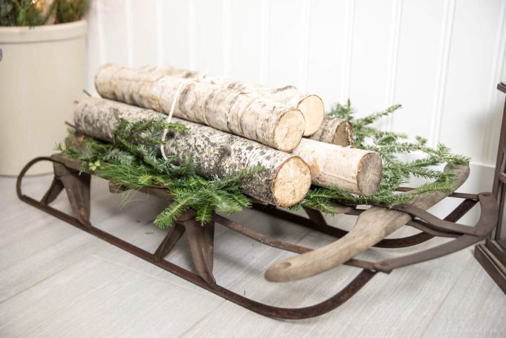 Vintage rustic sled with birch logs Christmas decor.