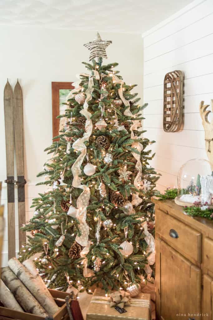 Rustic woodland-inspired Christmas tree with neutral vintage lace and a rattan star topper. 