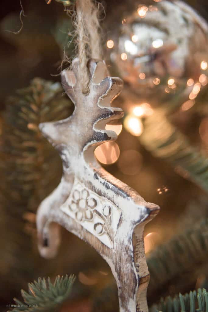 Wooden deer ornament with fairy lights in background