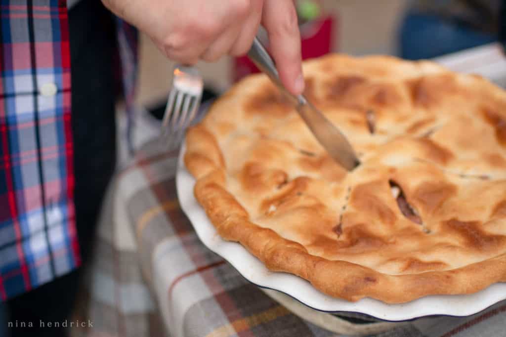 Cutting an apple pie at Friendsgiving