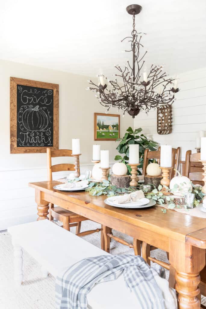 Fall Holiday dining room with a white bench and a warm wood table.