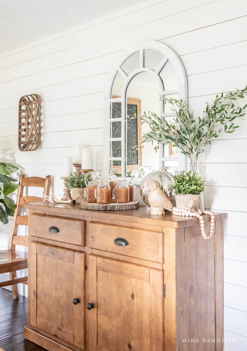 Warm pine buffet with a fall vignette and apple cider bar