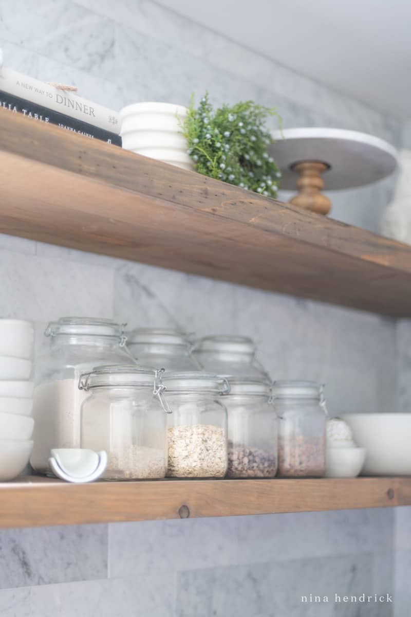 Incorporating glass jars with decanted dry goods into your open shelving in the kitchen