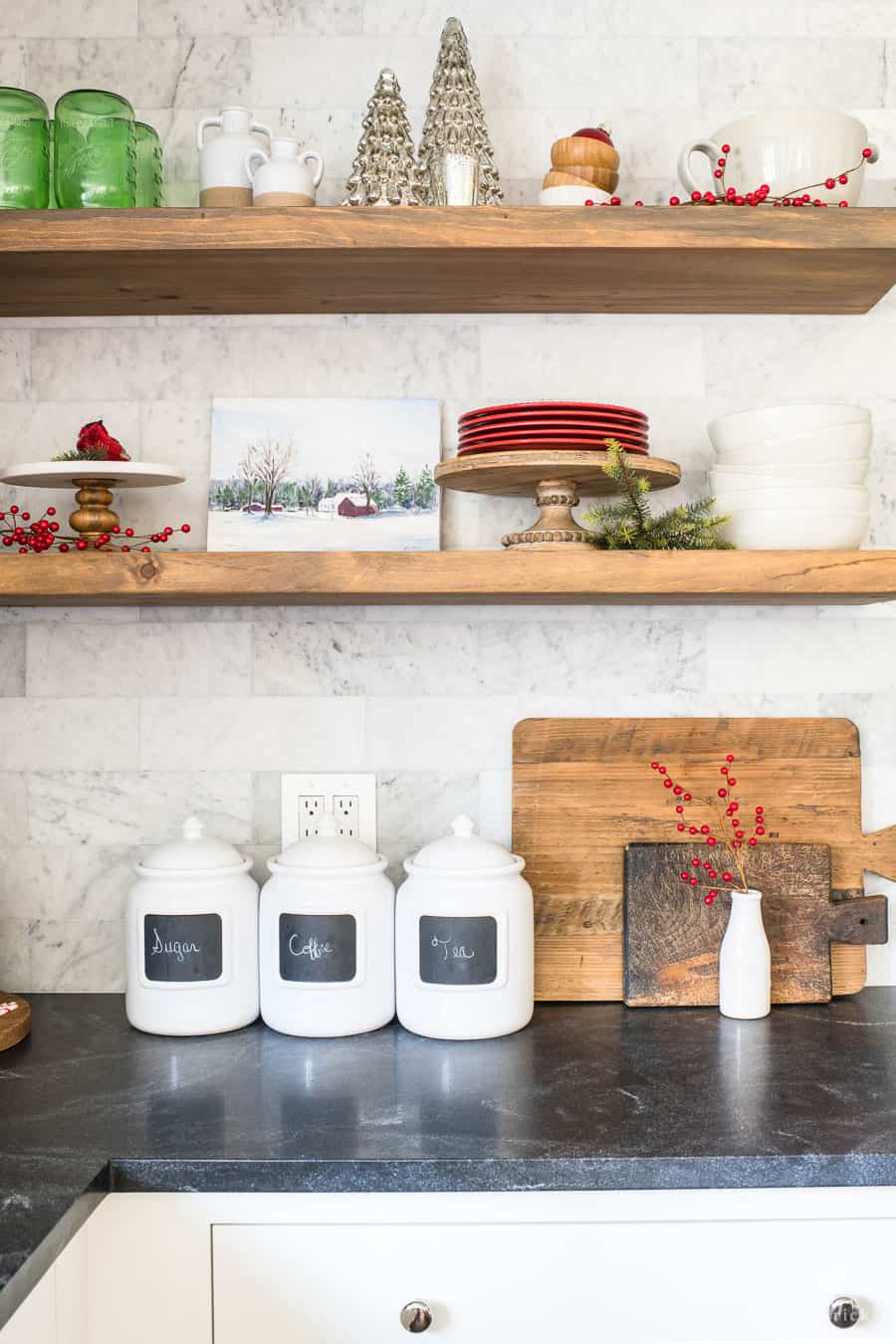 Christmas shelf decor ideas on wooden floating shelving with red plates and berries