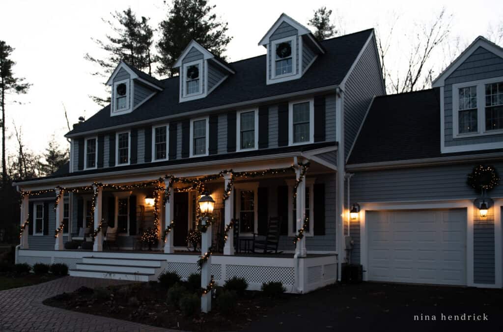 Blue gray house decorated for Christmas with lights and lanterns