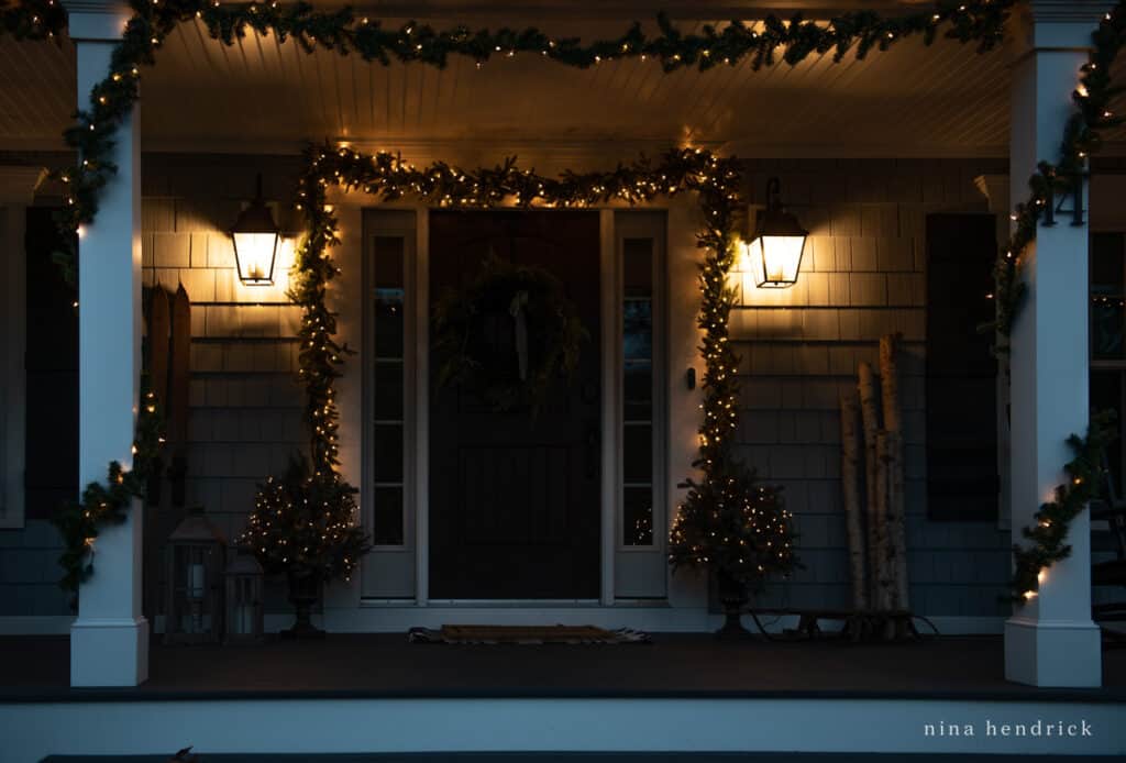Porch with Christmas light garlands wrapped around pillars and front door